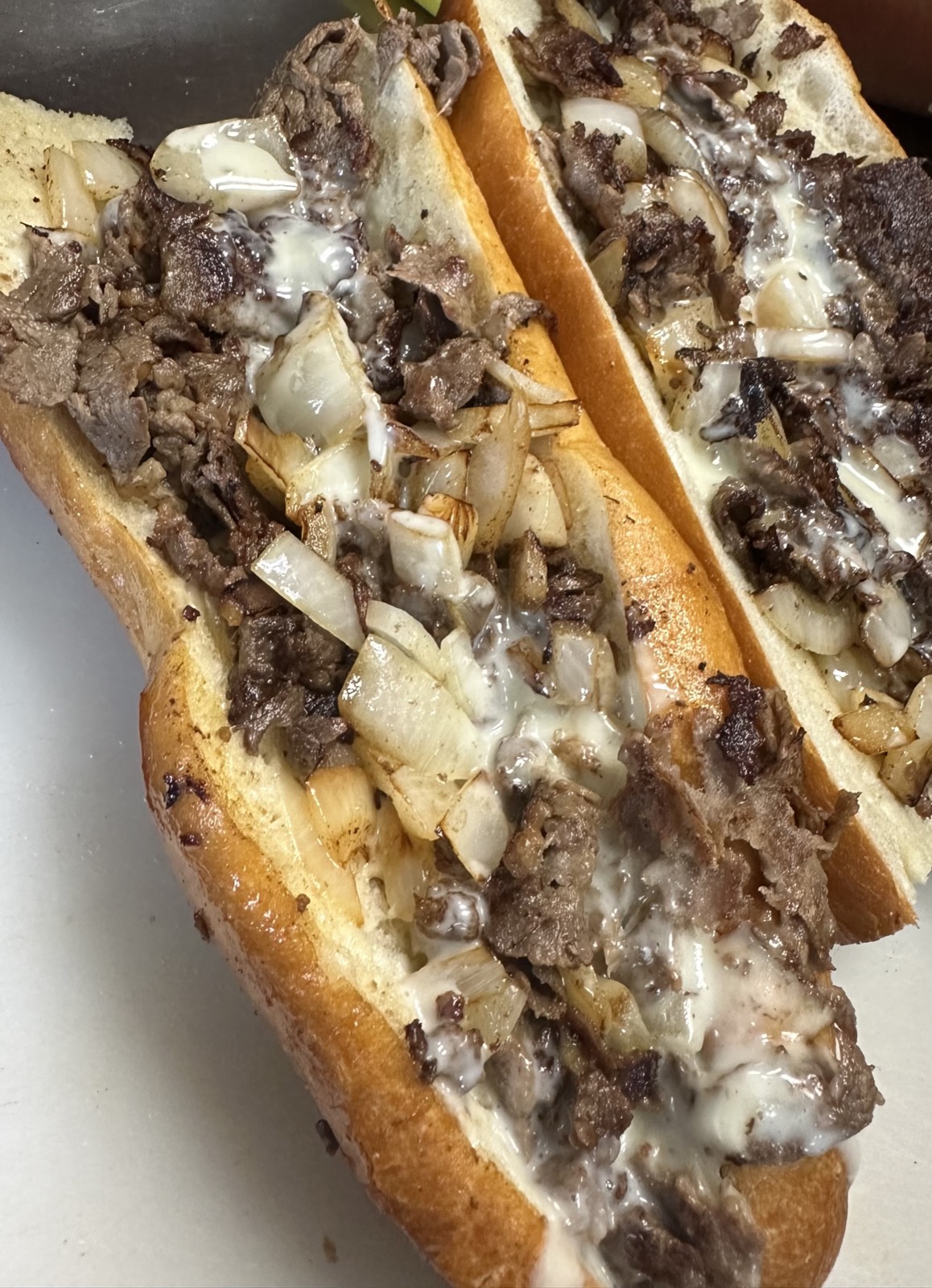 Cheesesteak on a long roll with onions and melted cheese