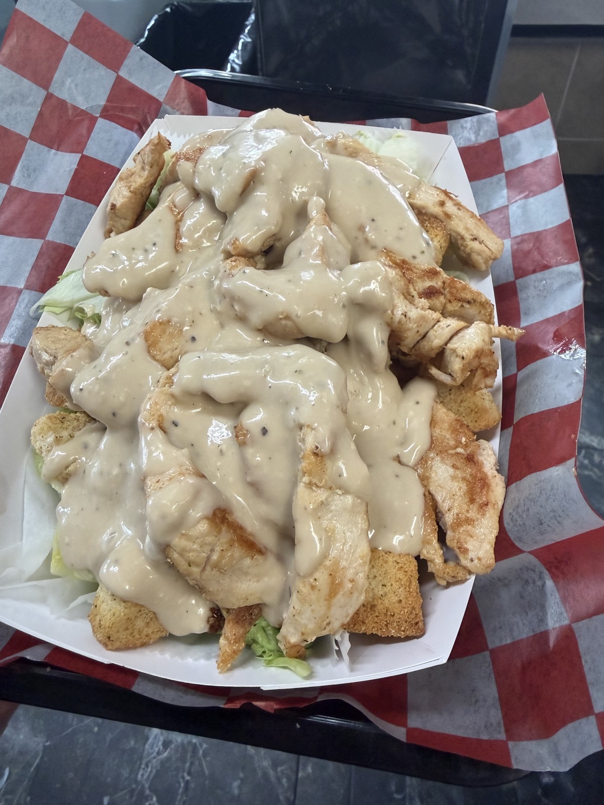 Chicken Caesar salad topped with creamy dressing